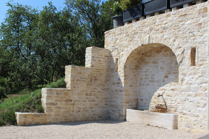 Photo mur en pierre avec voute et fontaine